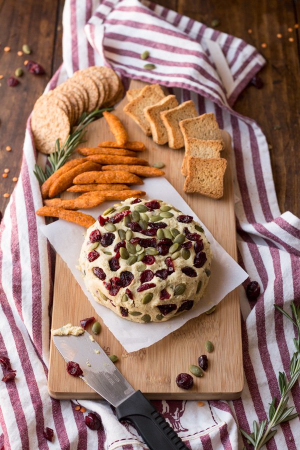 Vegan Lentil Cashew Cheese Ball - An easy vegan cheese recipe topped with cranberries and pumpkin seeds. Perfect for holiday or Christmas parties | ExSloth.com