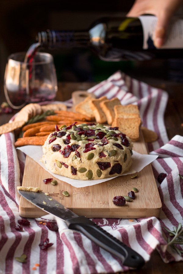 Vegan Lentil Cashew Cheese Ball - An easy vegan cheese recipe topped with cranberries and pumpkin seeds. Perfect for holiday or Christmas parties | ExSloth.com