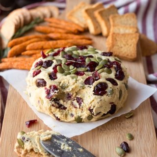 Vegan Lentil Cashew Cheese Ball - An easy vegan cheese recipe topped with cranberries and pumpkin seeds. Perfect for holiday or Christmas parties | ExSloth.com