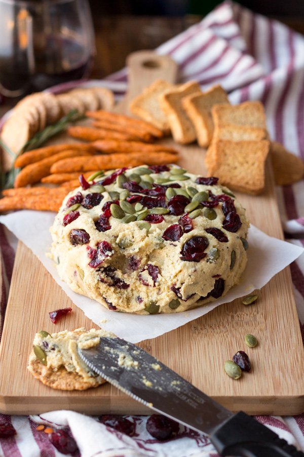 Vegan Lentil Cashew Cheese Ball - An easy vegan cheese recipe topped with cranberries and pumpkin seeds. Perfect for holiday or Christmas parties | ExSloth.com