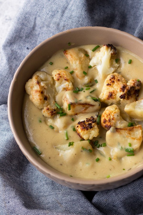 This cheesy vegan cauliflower soup is creamy, filling and bursting with flavour. It's also gluten-free, Whole30 approved and required just 1 hour and 10 ingredients. It's the perfect vegan soup for warming up on cold winter days | ExSloth.com