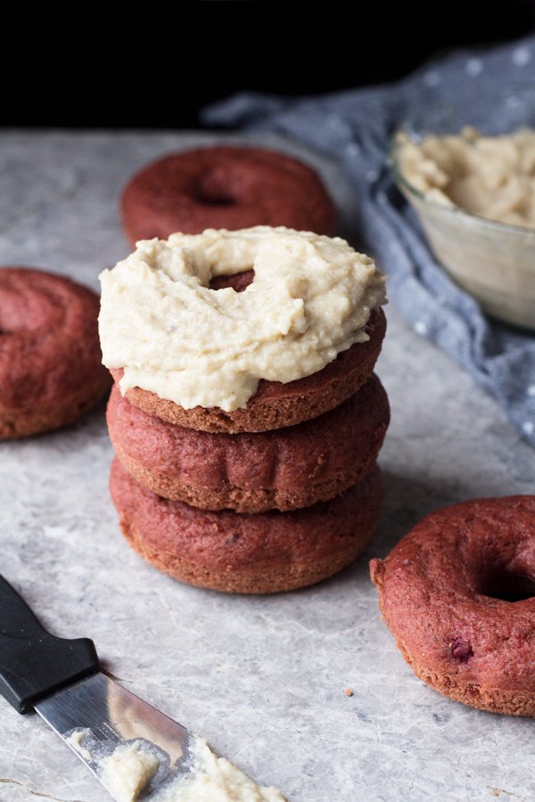 These vegan red velvet donuts are a delicious, healthy alternative to regular fried donuts and are great for Valentine's Day. The vegan cashew cream cheese frosting is also easy to make, creamy and perfectly sweet | ExSloth.com