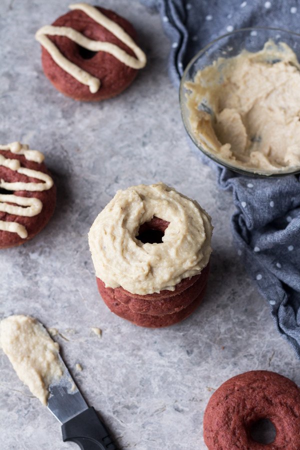 These vegan red velvet donuts are a delicious, healthy alternative to regular fried donuts and are great for Valentine's Day. The vegan cashew cream cheese frosting is also easy to make, creamy and perfectly sweet | ExSloth.com