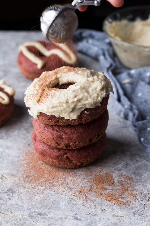 These vegan red velvet donuts are a delicious, healthy alternative to regular fried donuts and are great for Valentine's Day. The vegan cashew cream cheese frosting is also easy to make, creamy and perfectly sweet | ExSloth.com