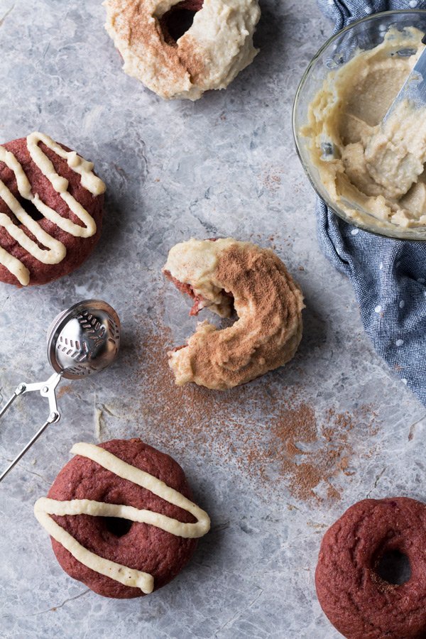 These vegan red velvet donuts are a delicious, healthy alternative to regular fried donuts and are great for Valentine's Day. The vegan cashew cream cheese frosting is also easy to make, creamy and perfectly sweet | ExSloth.com